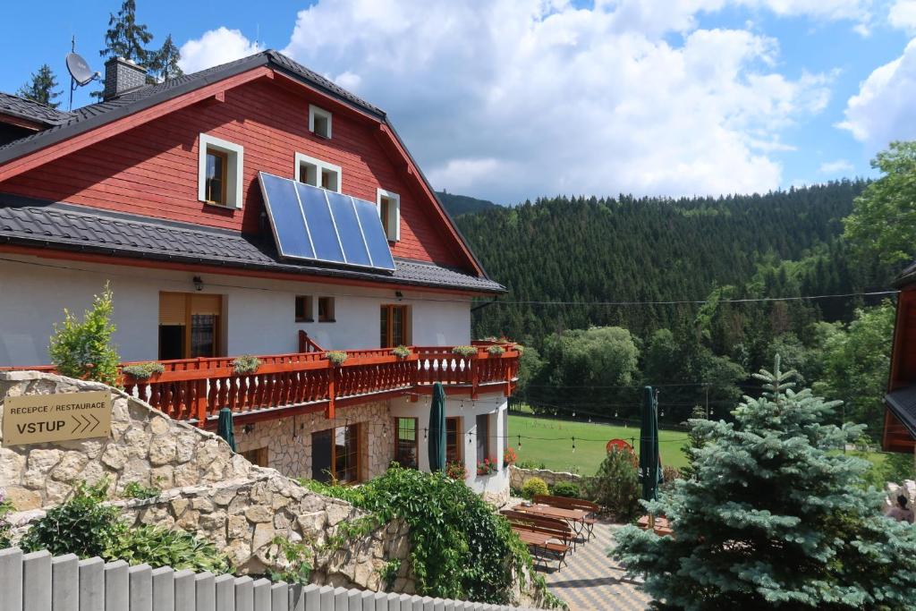 a house with a solar panel on the roof at Penzion Bawaria in Horní Lomná