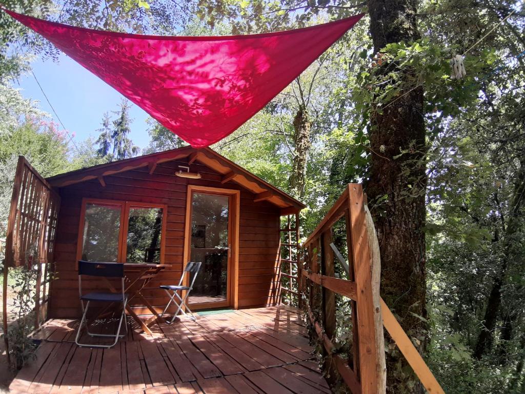una cabaña en el bosque con una tienda roja en la cubierta en Chalet Ekowün, en Payrignac