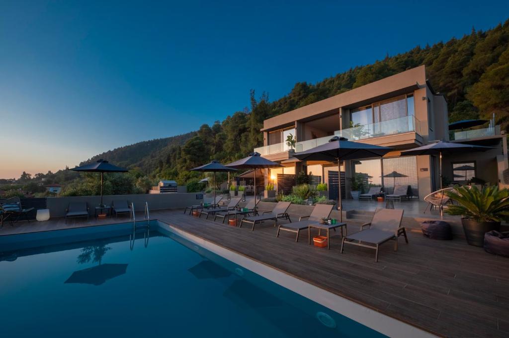 a villa with a swimming pool at night at Anmian Suites in Vourvourou