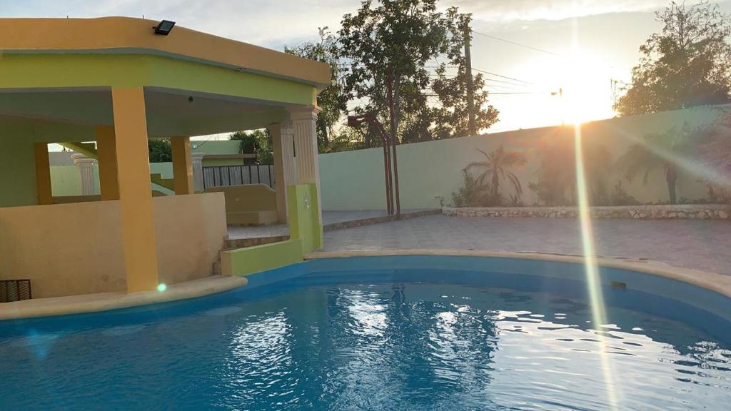 a swimming pool in a house with the sun setting at Villa Victoria in La Romana