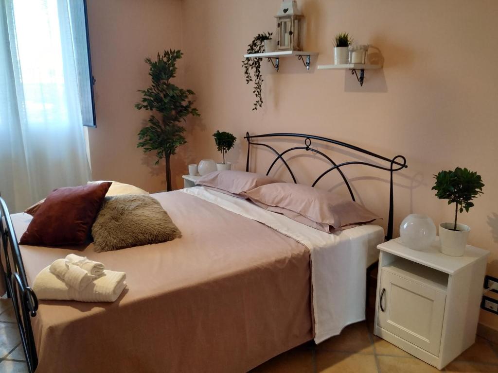 1 dormitorio con 1 cama con sábanas blancas y almohadas rosas en Carabion, en Mascali