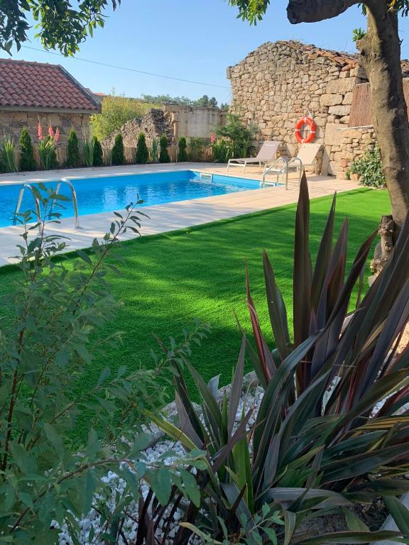a backyard with a swimming pool and a lawn at Villa Candoso in Candoso