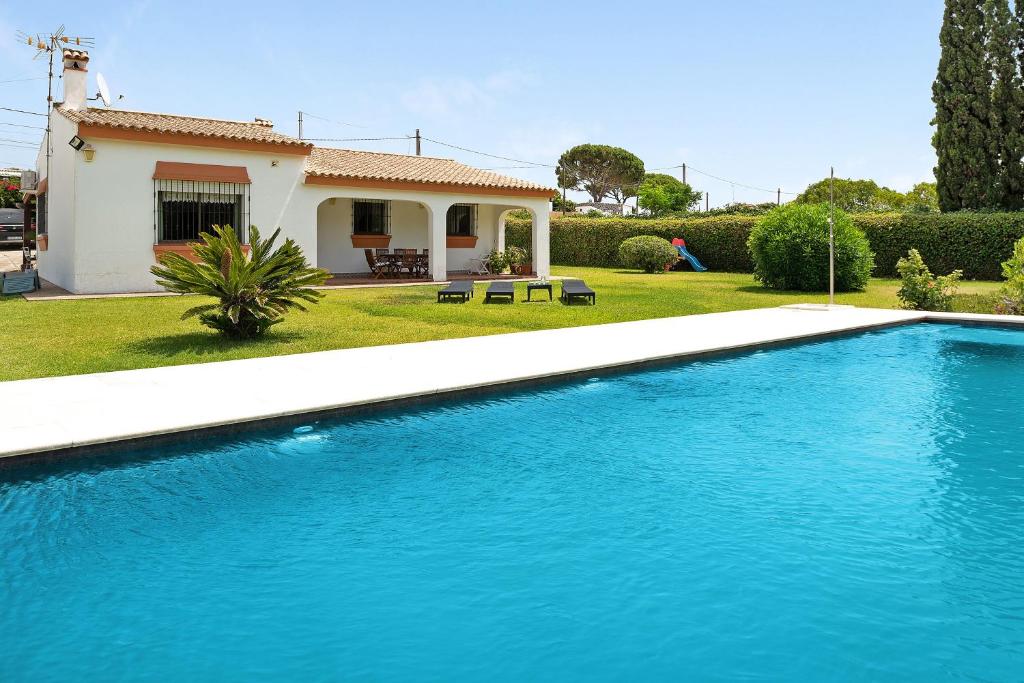 a swimming pool in front of a house at Casa Los Alamos in La Muela