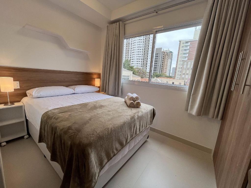 Un dormitorio con una cama con un osito de peluche. en Studios Modernos Totalmente Mobiliados com Academia Próximo a Metrô Parque Ibirapuera e Hospitais en São Paulo