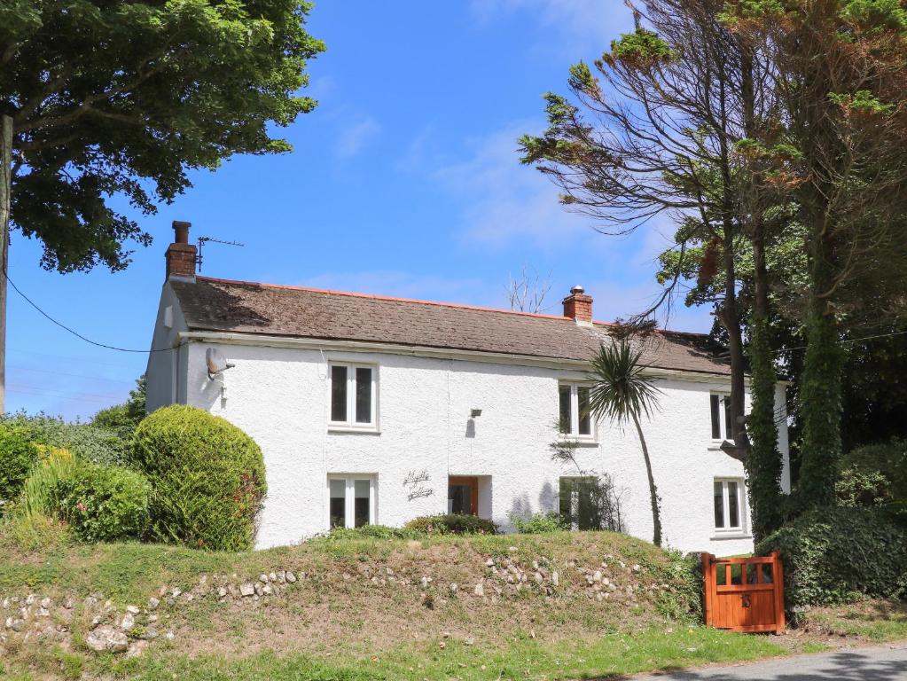 una casa bianca seduta in cima a una collina di Myrtle Cottage a Hayle