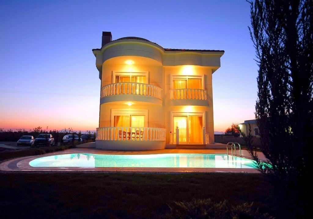 a large house with a pool in front of it at Sadev Turizm Belek Family Villas in Belek