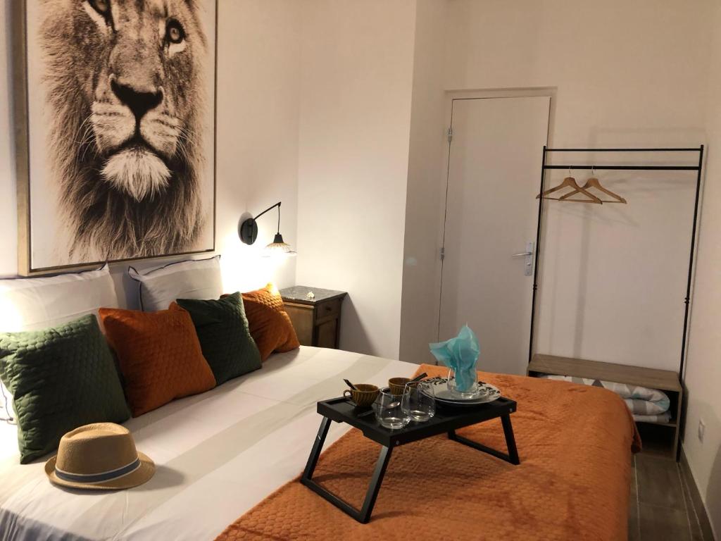 a bedroom with a bed with a lion picture on the wall at Le Logis de Virginie in Rochefort