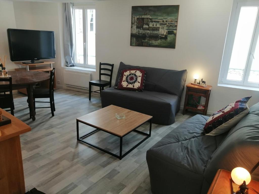 uma sala de estar com um sofá e uma mesa em F Logement entier em Courtenay