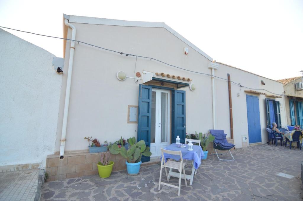 a patio with a blue table and chairs in front of a building at Il pesce nero in Portopalo