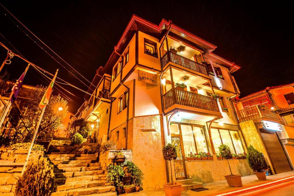 a building with stairs in front of it at night at Семеен Хотел Бачково in Bachkovo