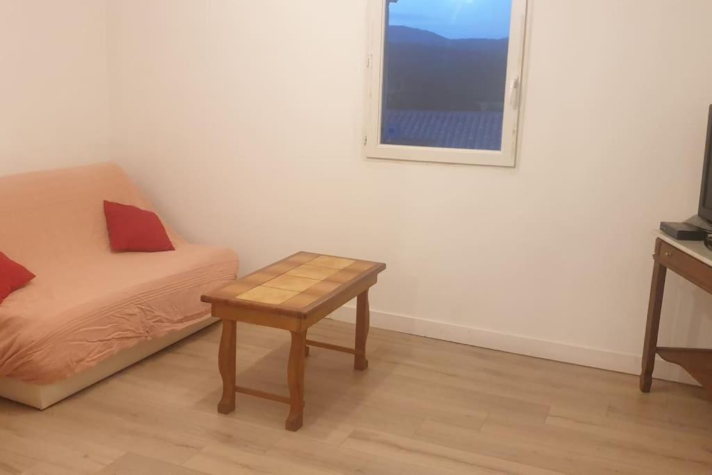 a room with a bed and a table and a window at Maison de Village avec Jardinet à Revest du bion in Revest-du-Bion