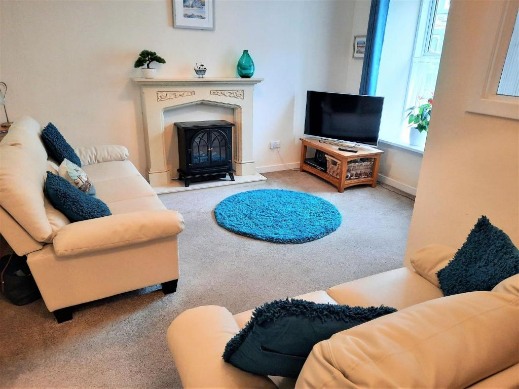 a living room with two couches and a fireplace at The Granite House in Newton Stewart