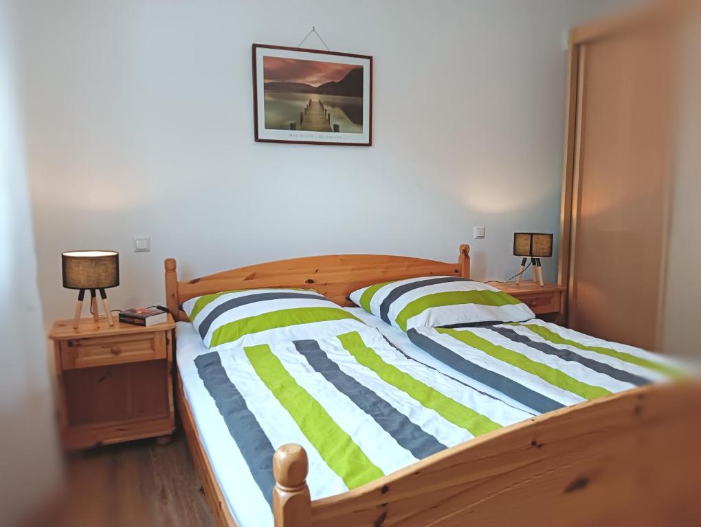 1 dormitorio con cama de madera con rayas verdes y azules en Ferienwohnung Pinzenhof - Kemnath en Kemnath