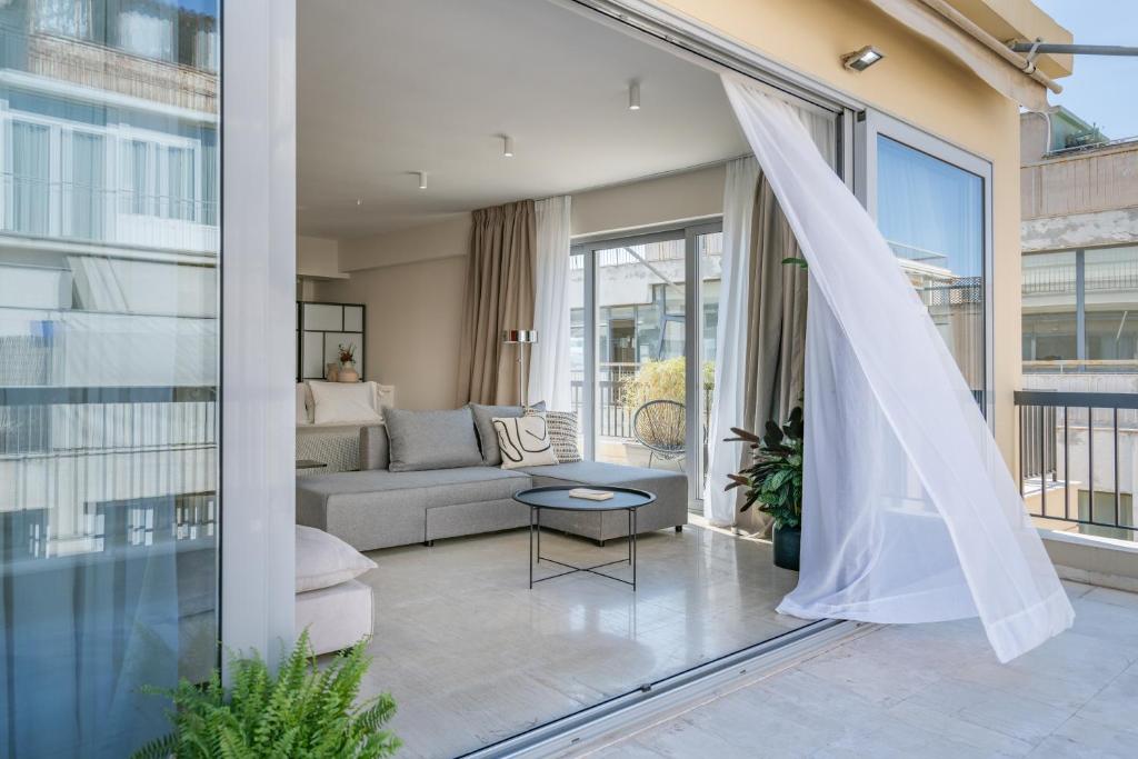 een woonkamer met een bank en een raam bij The Artisan Suites in Athene