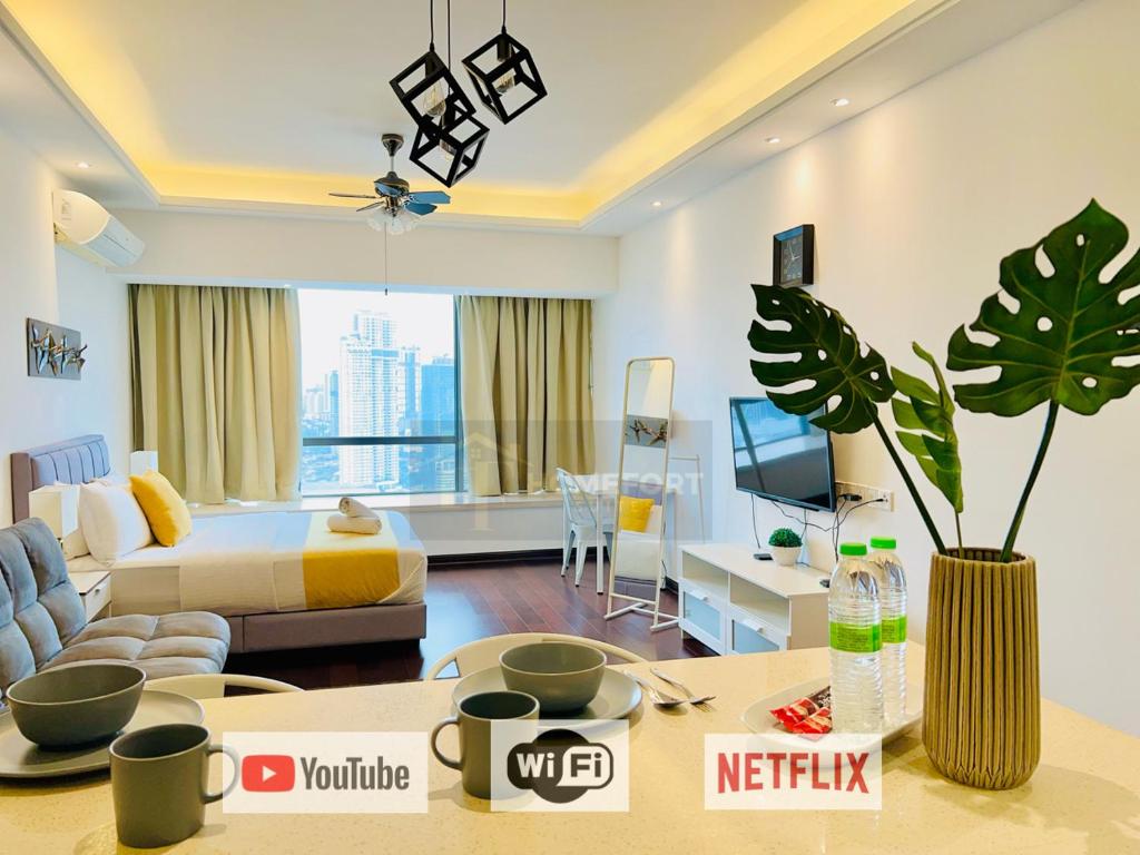 ein großes Wohnzimmer mit einem Bett und einem Wohnzimmer in der Unterkunft R&F PRINCESS COVE BY HOMEFORT SUITES in Johor Bahru