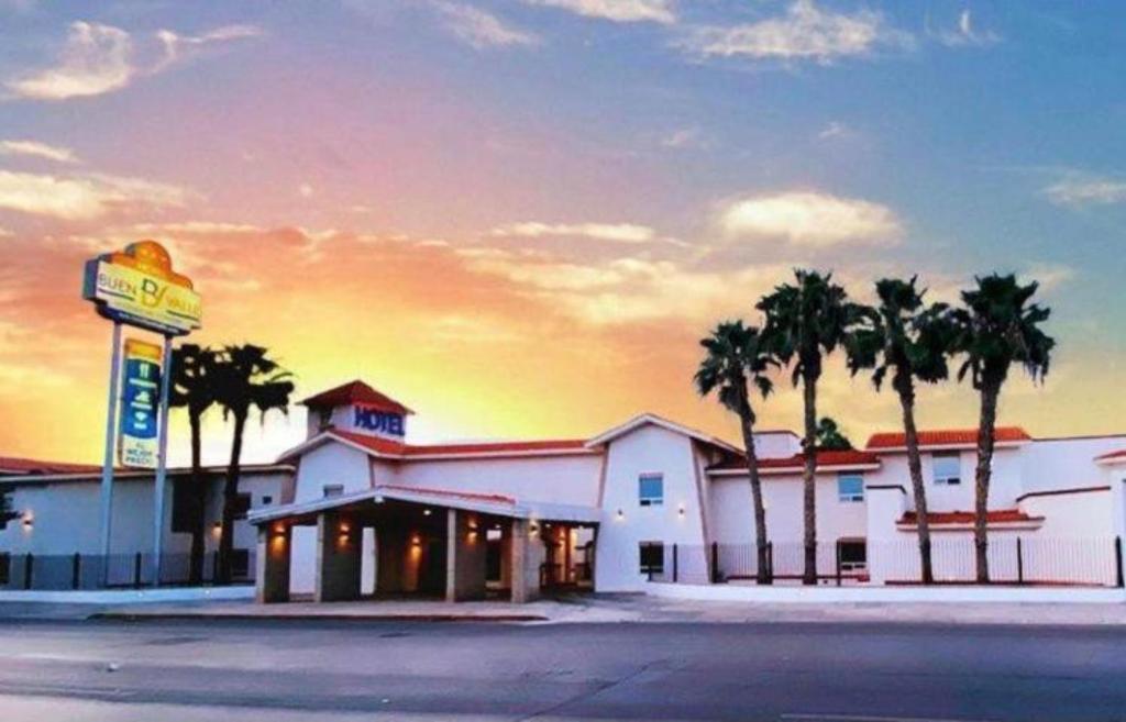 um motel com palmeiras em frente a um edifício em Hotel Buen Valle em Torreón