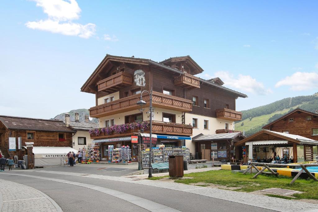 een groot gebouw met een klok aan de kant van een straat bij La Sorgente Appartamento Martin in Livigno