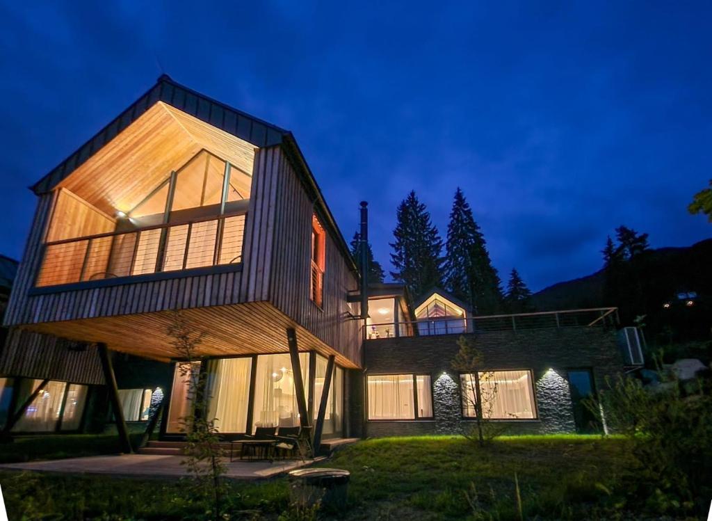 duży drewniany dom z mnóstwem okien w obiekcie Chalet STRÖMY Demänovská dolina w Liptowskim Mikulaszu