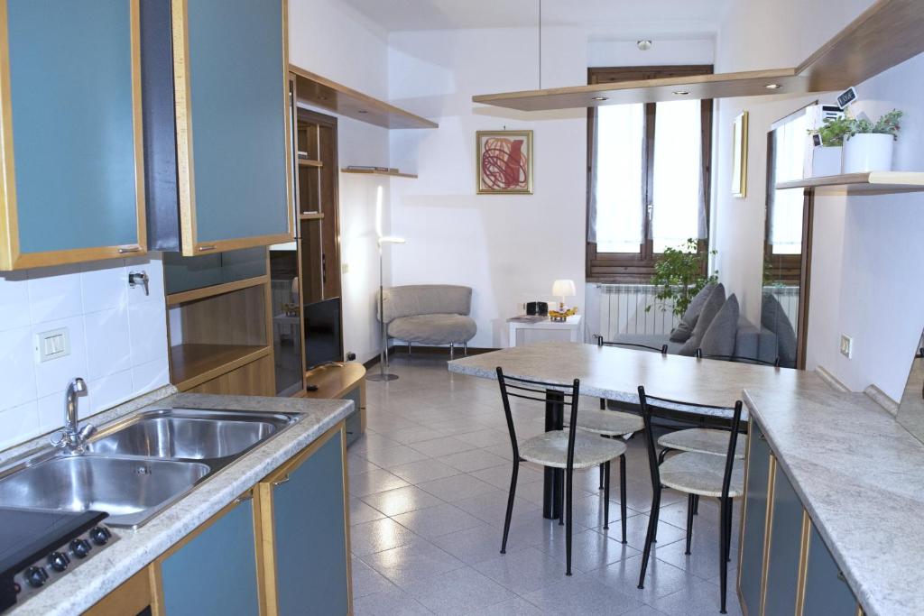 a kitchen with a sink and a table with chairs at Casa Mafalda in Torre Boldone