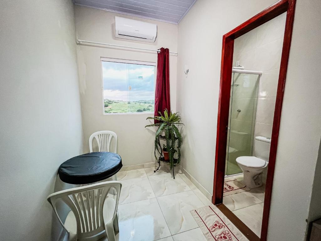 a bathroom with a toilet and a sink and a window at Pousada Serrana in Serra de São Bento