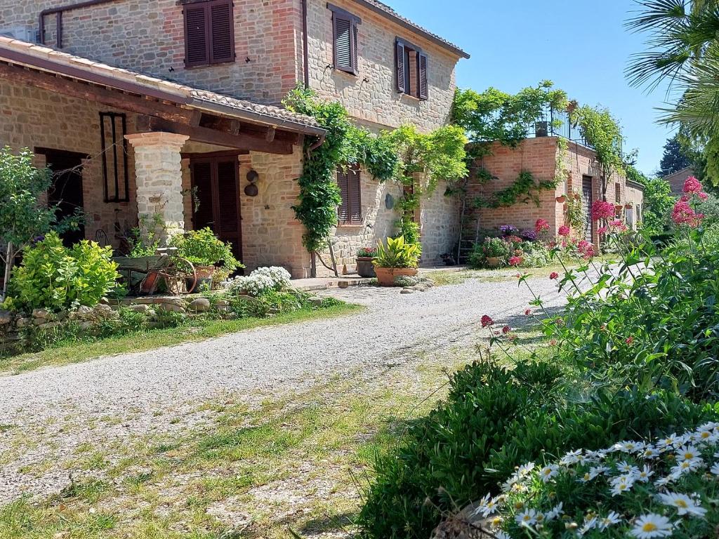 a stone house with a road in front of it at Casale San Martino Agriturismo Bio in SantʼAngelo in Pontano
