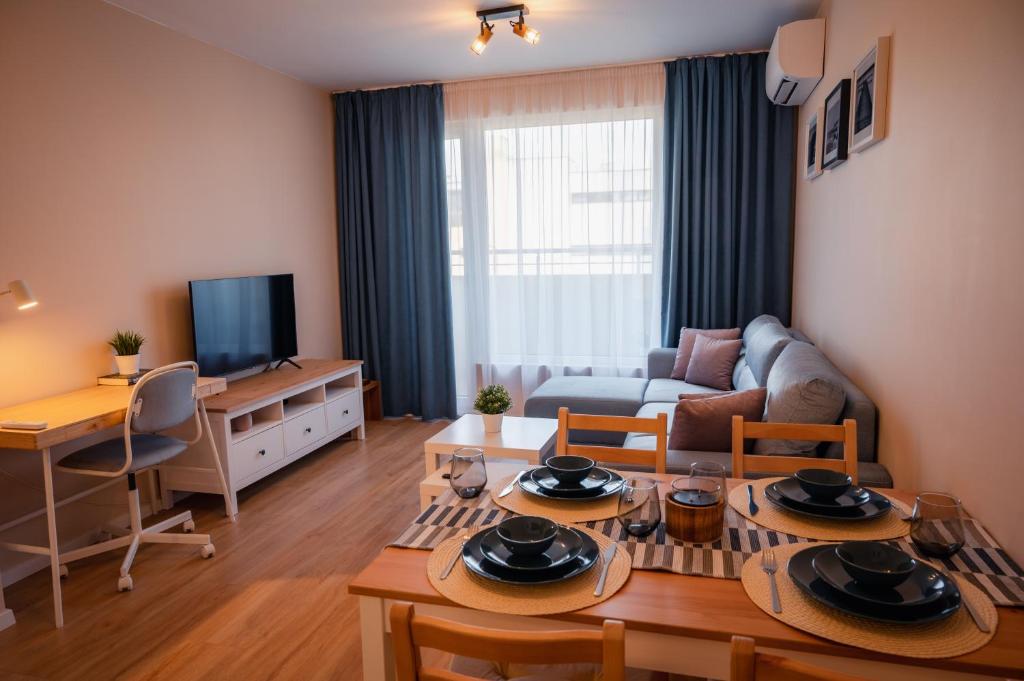 a living room with a couch and a table at EMERALD SUITE with private parking in Varna City