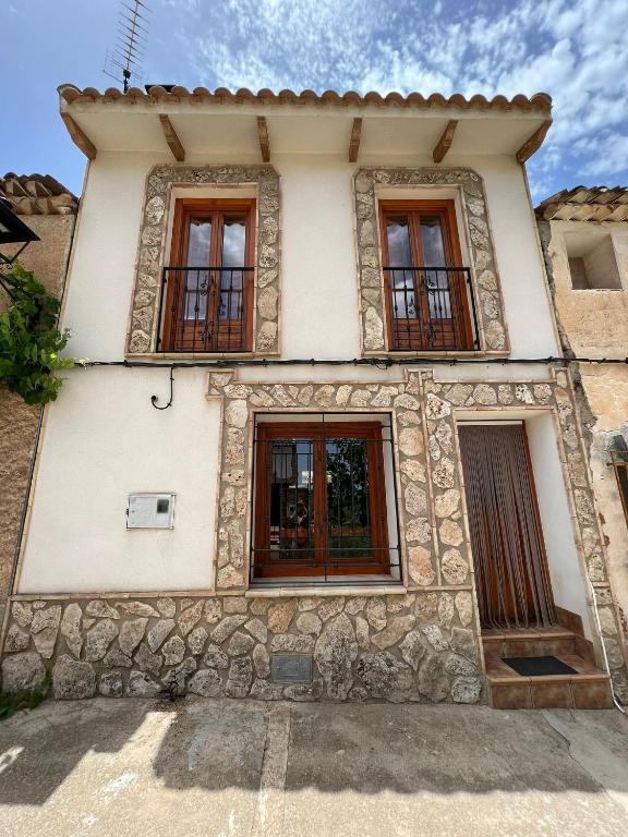 an old stone house with windows on a street at Casa Rural - Vivienda Yunque in Puerto del Pino