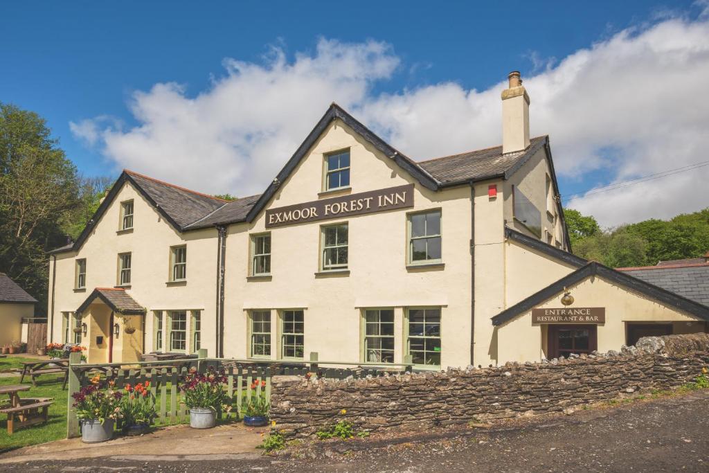 un edificio blanco con un letrero que lee la posada del almuerzo en The Exmoor Forest Inn, en Simonsbath