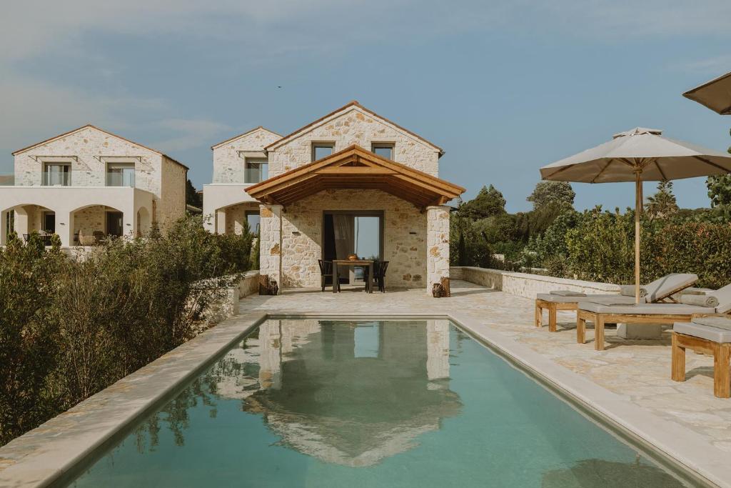 una casa con piscina frente a una casa en Nama Seaside Villas, en Paralia Kanaliou