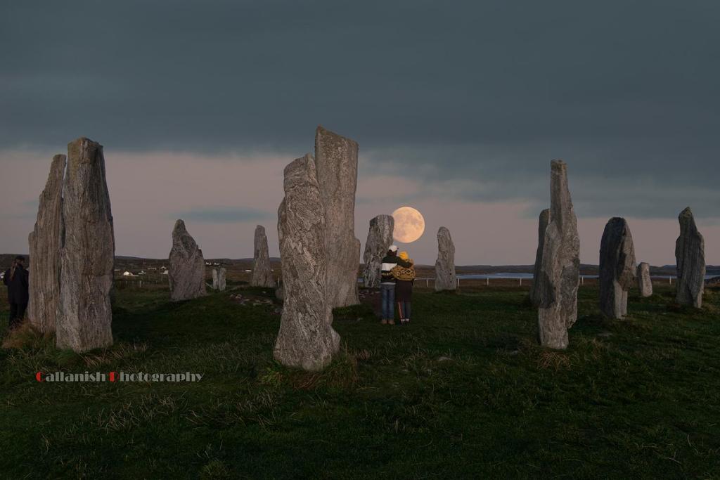 a person standing in front of a group of stone monuments at 21 Callanish Luxury Pod in Callernish
