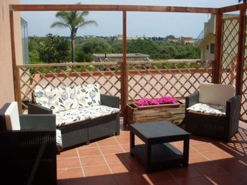un patio con 2 sofás, una mesa y sillas en Vespri Siciliani, en Avola