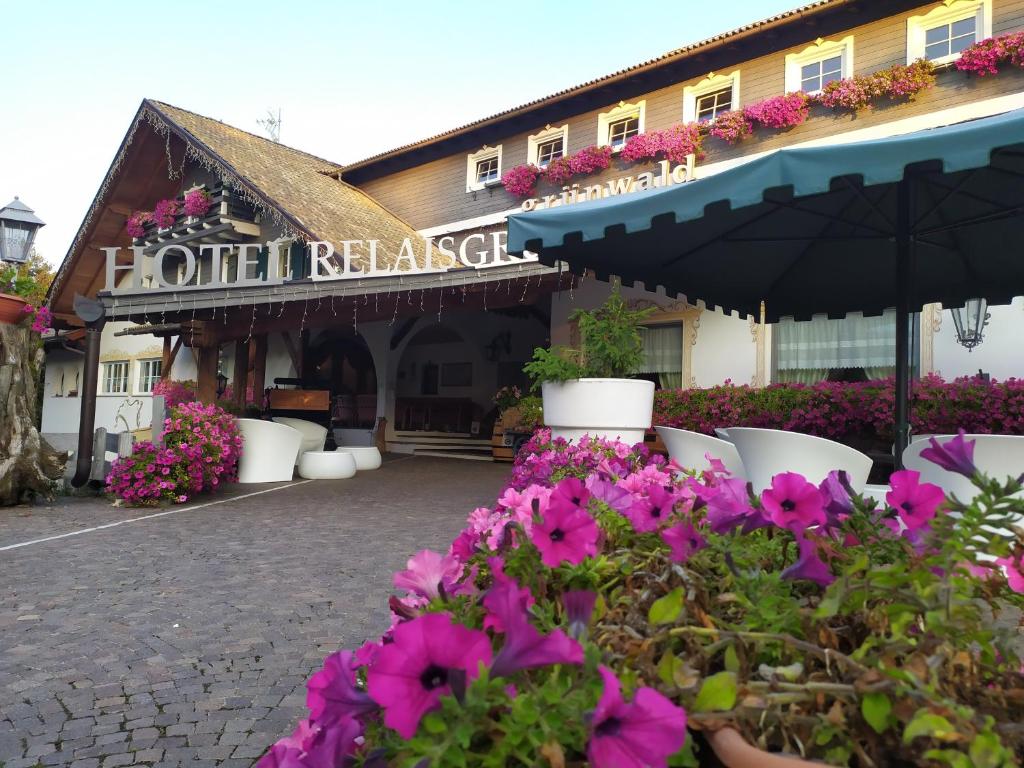 een hotel met bloemen voor een gebouw bij Hotel Relais Grünwald in Cavalese