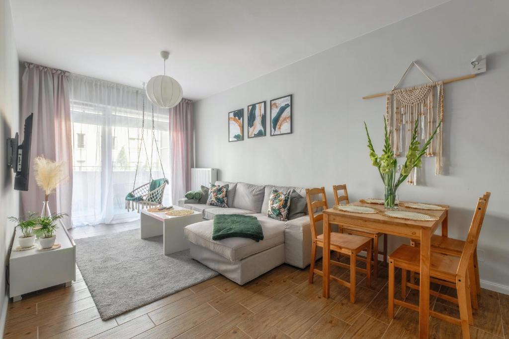 a living room with a couch and a table at Boho Apartment Janów z miejscem parkingowym in Łódź