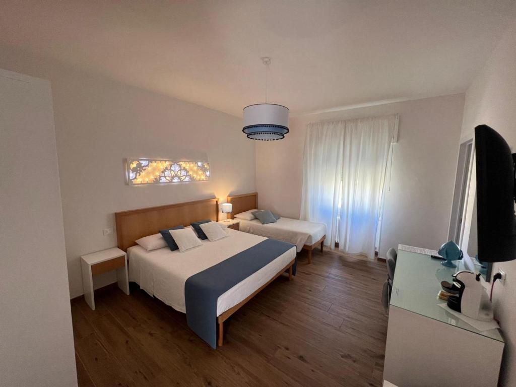 una camera d'albergo con due letti e una televisione di B&B Venti di Mare a Otranto