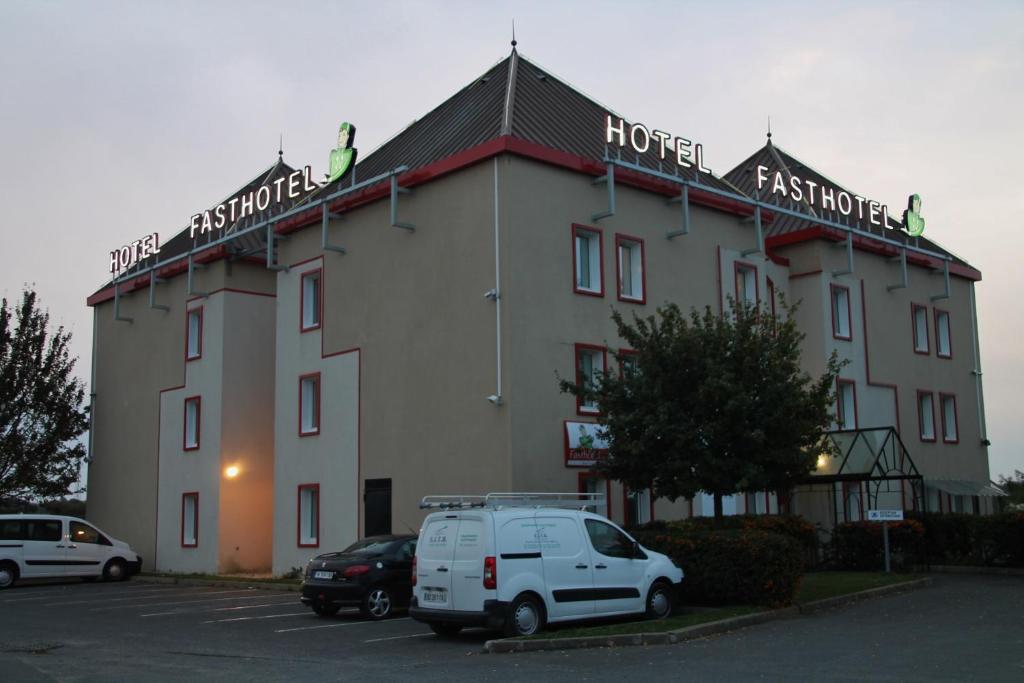 un gran edificio con una furgoneta blanca estacionada en un estacionamiento en Fasthotel Montereau - Esmans, en Esmans