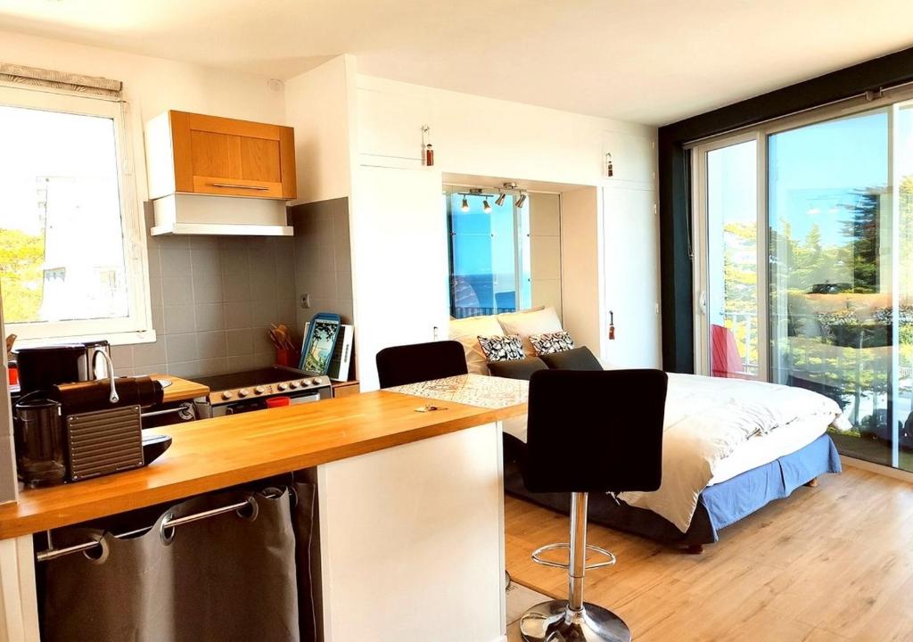 a bedroom with a bed and a kitchen with a counter at Loueurdappart - Studio Cosy, Très jolie Vue Mer, Tout à pied à la Baule in La Baule