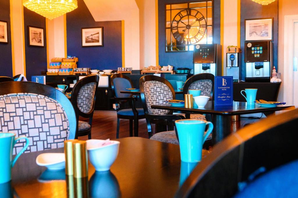 a dining room with tables and chairs in a restaurant at Llandudno Bay Hotel in Llandudno
