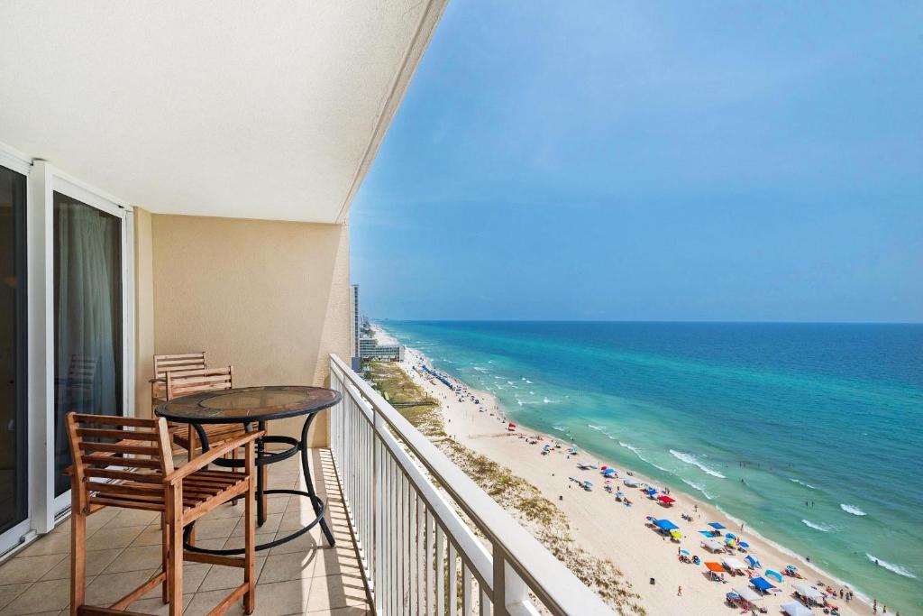a balcony with a table and chairs and the beach at Emerald Beach 1627 in Panama City Beach