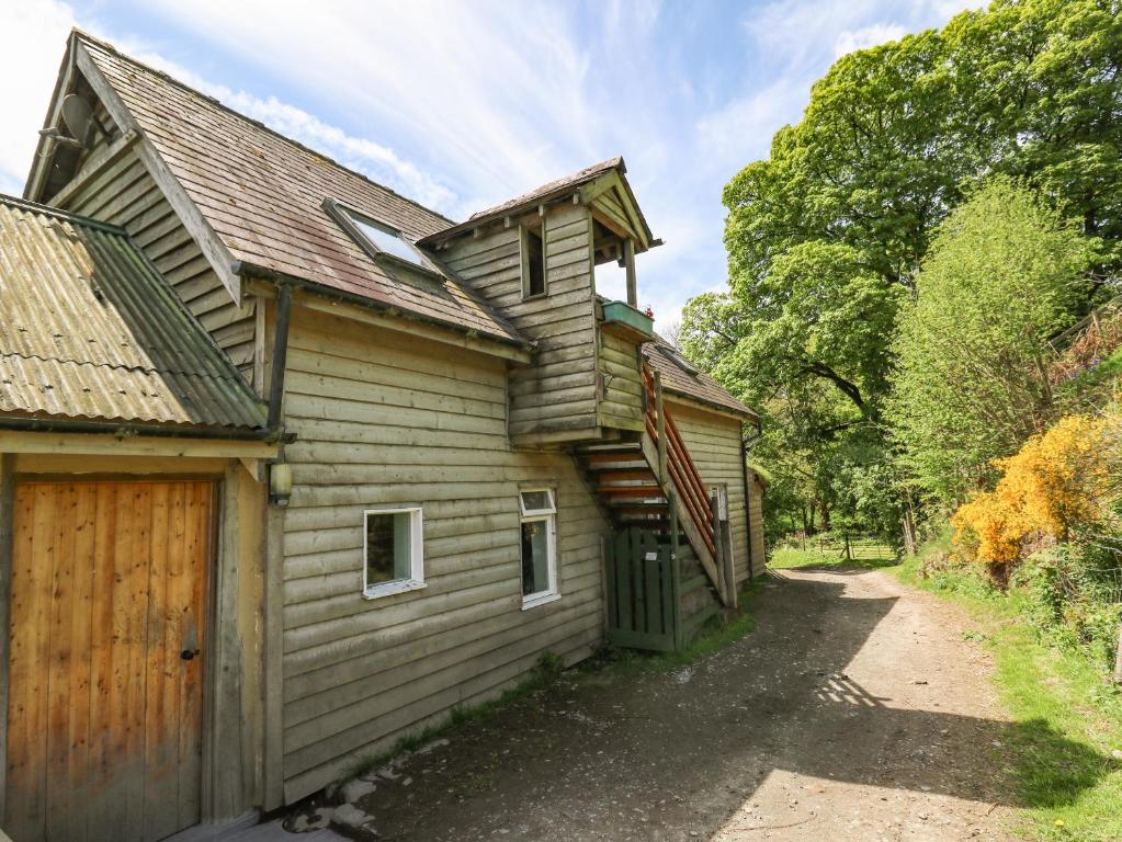 an old wooden house with a driveway next to it at The Loft in Llangunllo