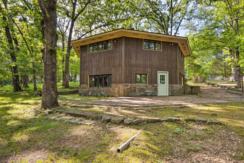 a large house with a garage in the woods at Rogers Cabin with Direct Access to Beaver Lake! in Garfield