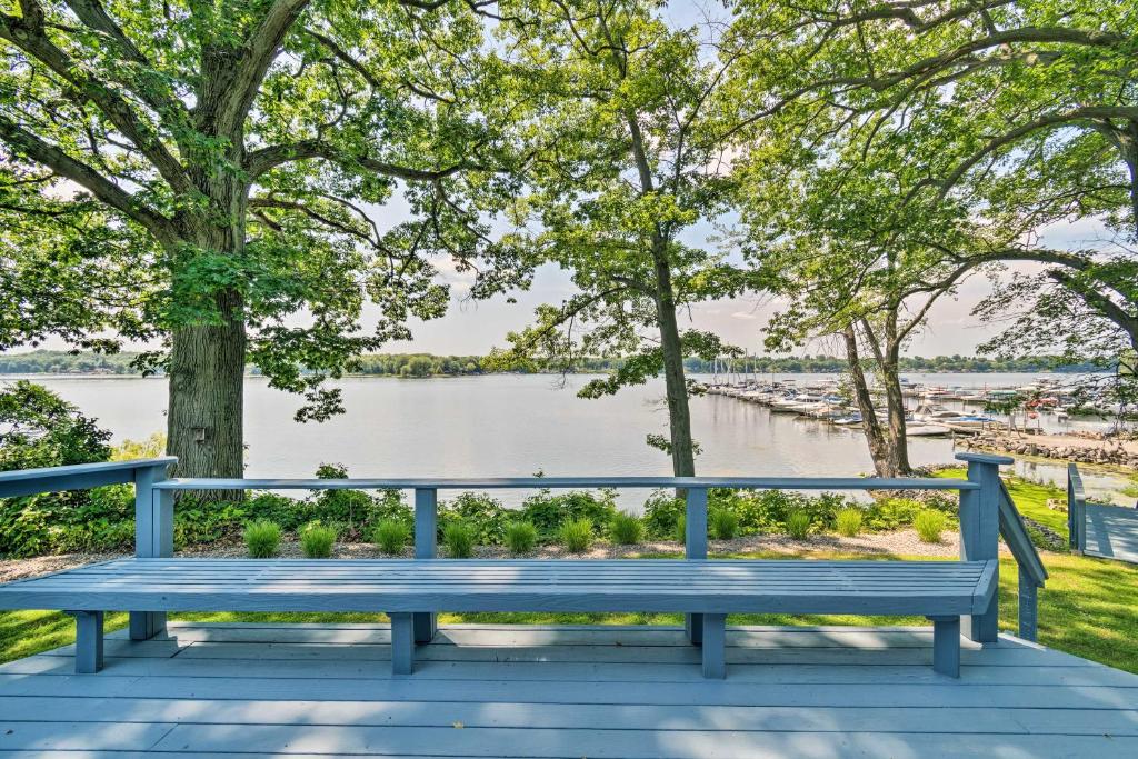 un banc bleu assis sur une terrasse surplombant la rivière dans l'établissement Charming Cottage on Sodus Bay Deck and Grill!, 