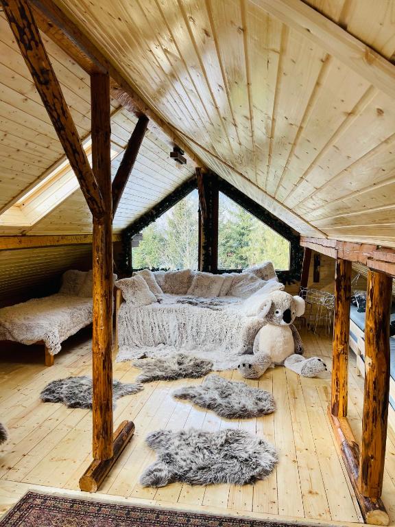Habitación con cama y almohadas en el suelo de madera. en Casa Renilor, en Azuga