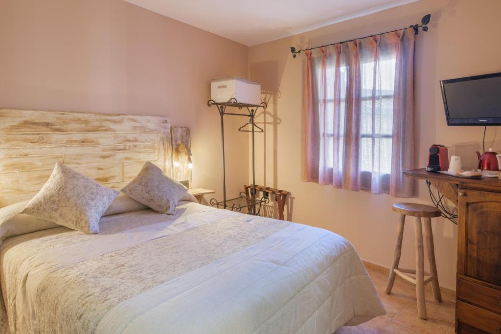 Un dormitorio con una cama grande y una ventana en El Rincón de Andrea Habitaciones, en Biescas