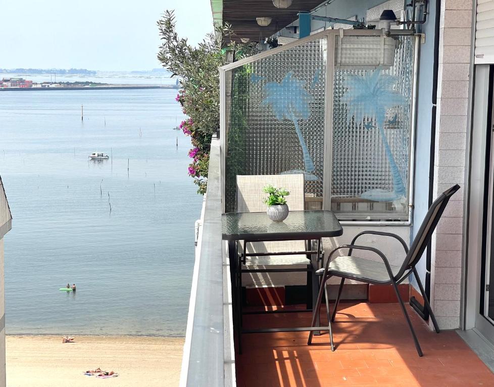 un tavolo e sedie su un balcone con vista sull'acqua di Apartamento Vilagarcía de Arousa -Playa 7 - Rías Baixas a Vilagarcia de Arousa