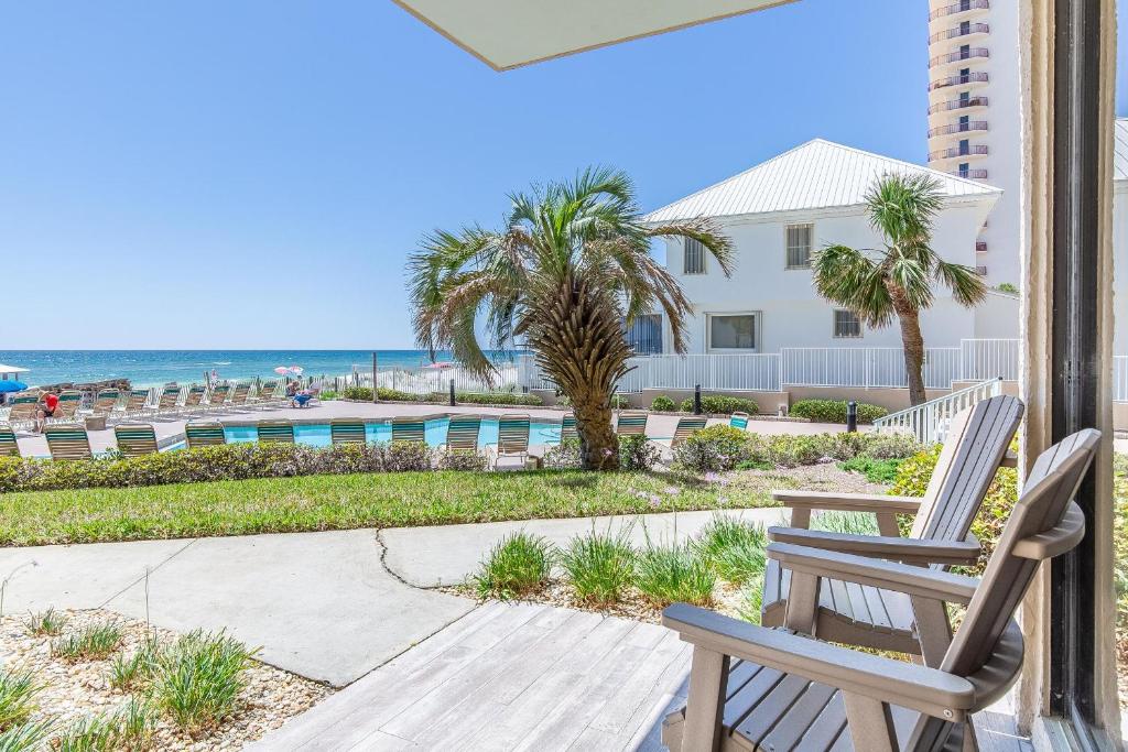 - une terrasse couverte avec 2 chaises et la plage dans l'établissement Pelican Walk 109, à Panama City Beach