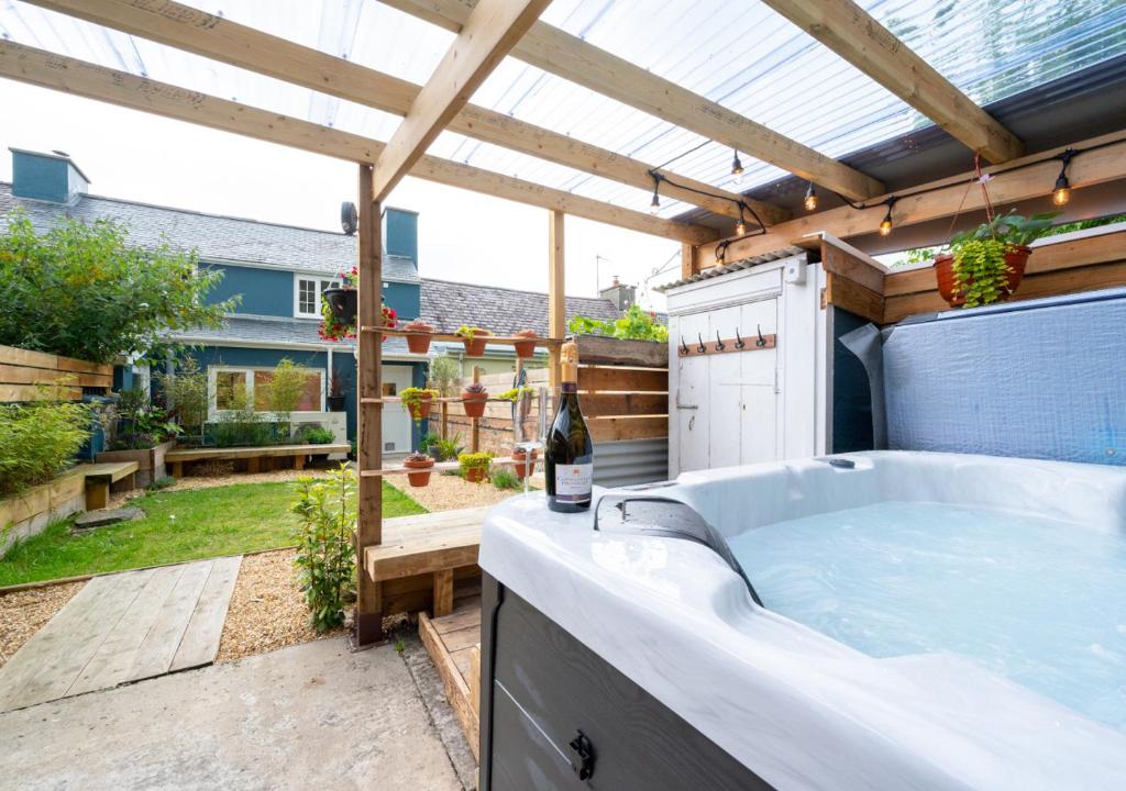 a hot tub in a backyard with a pergola at Rhyd y Fen in Aberaeron