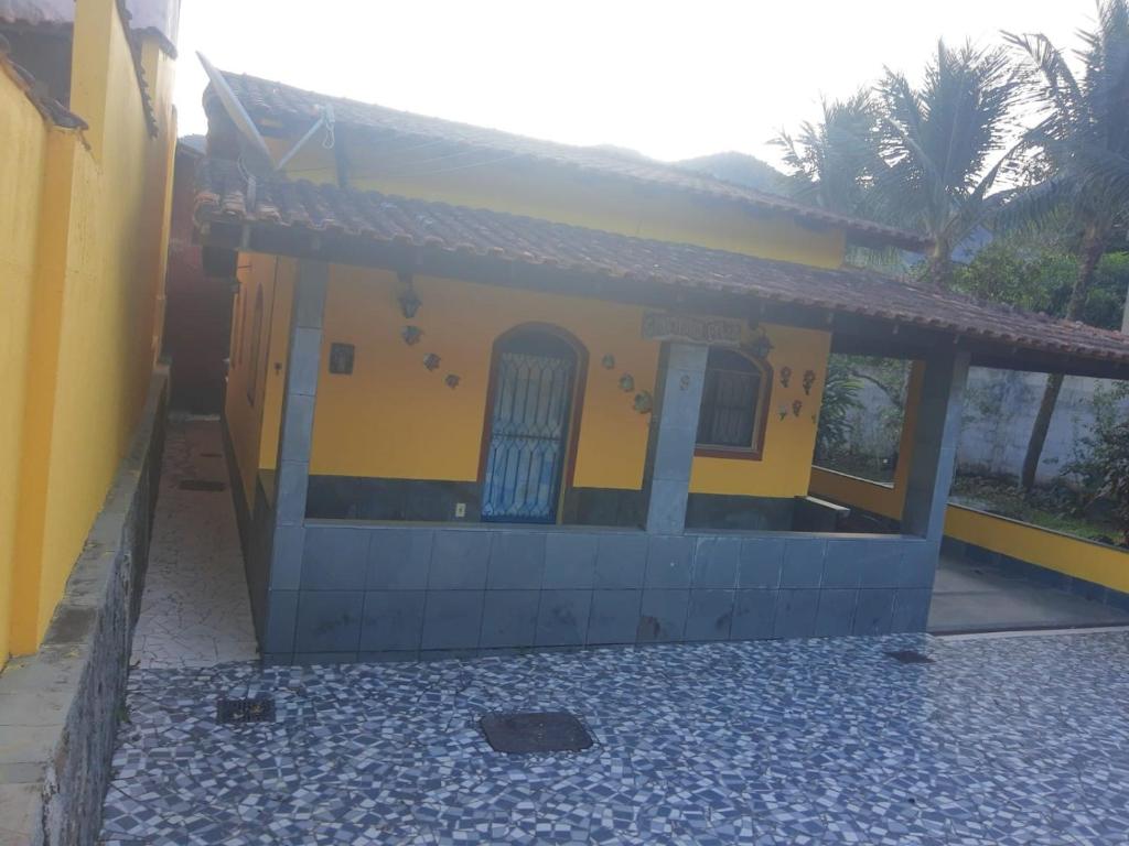 CASA COMPLETA-CONCEIÇÃO DE JACAREÍ -COSTA VERDE في مانغاراتيبا: منزل أصفر وأزرق مع شرفة