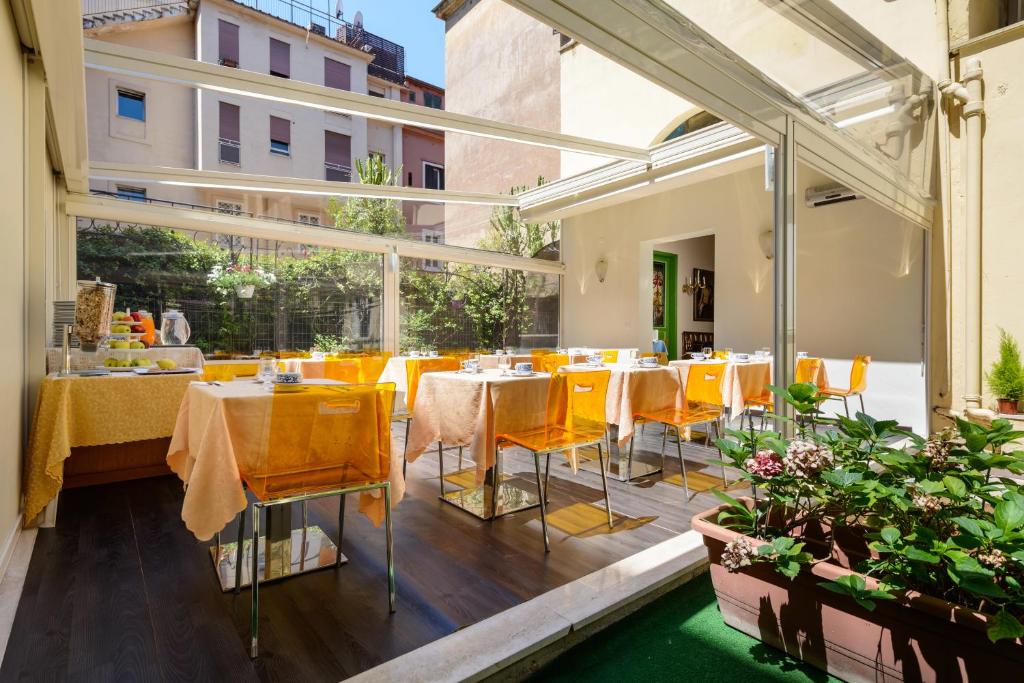 a restaurant with yellow tables and chairs on a balcony at Hotel St. Moritz in Rome