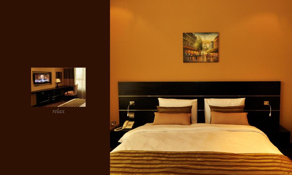 Postel nebo postele na pokoji v ubytování Aldar Hotel