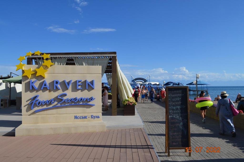 un letrero para un restaurante de marisco mariner honolulu en un paseo marítimo en Иссык-Куль ЦО "Karven Four Seasons" таунхаус, en Chon-Sary-Oy